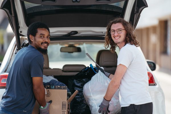 donation attendants getting stuff out of the back of a car